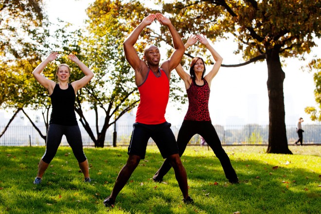 5 étapes pour vous créer votre entraînement personnalisé A group of people doing jumping jacks in the park